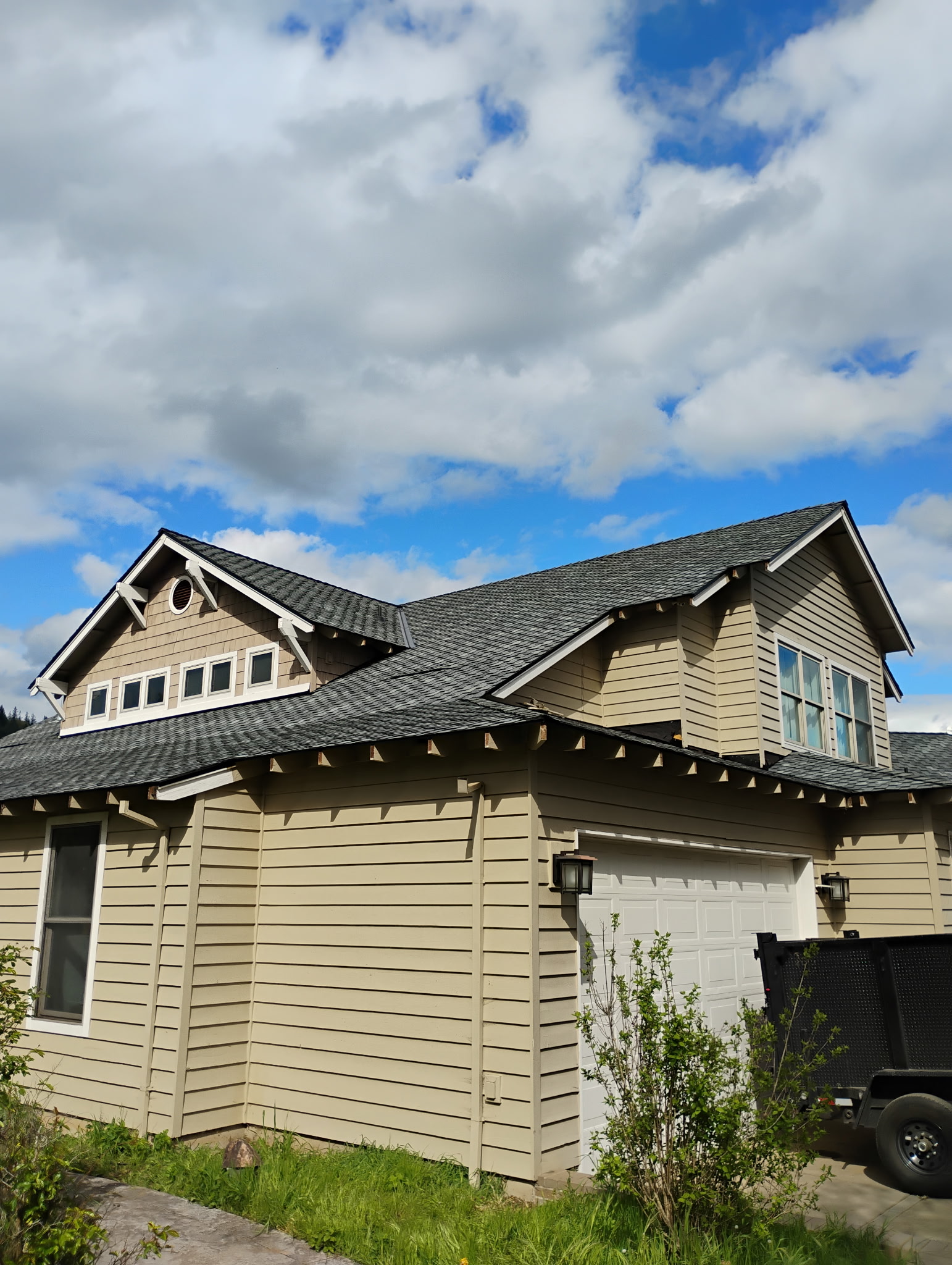 Completed craftsman-style home with a new dark shingle roof