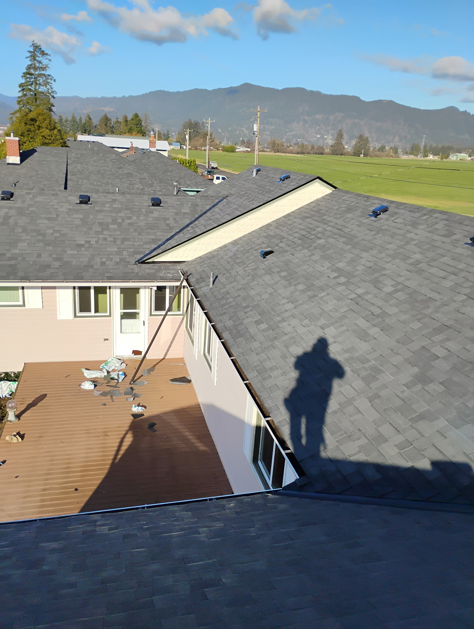 Completed shingle roof with a mountain backdrop, one of Top Value Roofing's finished jobs