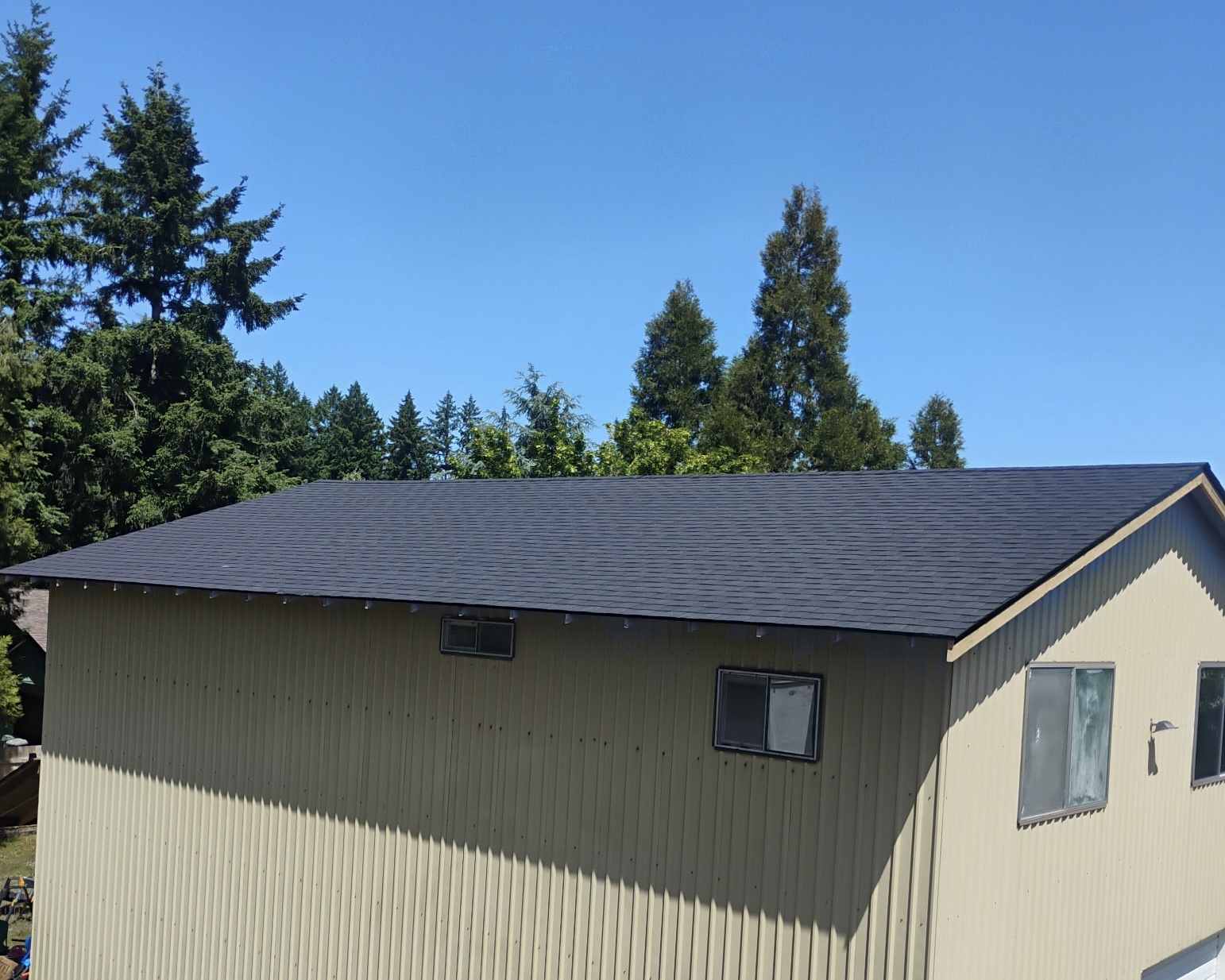 Completed dark shingle roof on a shop building